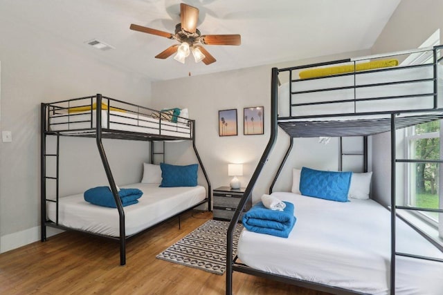 bedroom featuring baseboards, wood finished floors, and visible vents