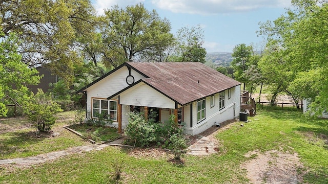 view of front of home featuring central air condition unit and a front yard