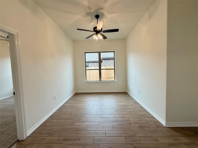 empty room with ceiling fan, baseboards, and wood finished floors