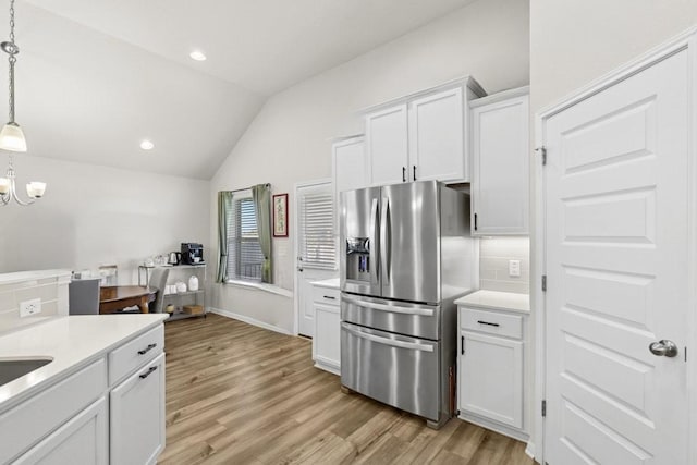 185 Dogvane Cir, Kyle, TX 78640 - kitchen with stainless steel refrigerator with ice dispenser, lofted ceiling, tasteful backsplash, light wood-style floors, and recessed lighting
