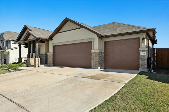 185 Dogvane Cir, Kyle, TX 78640 - view of front of house featuring a garage, concrete driveway, stucco siding, and stone siding