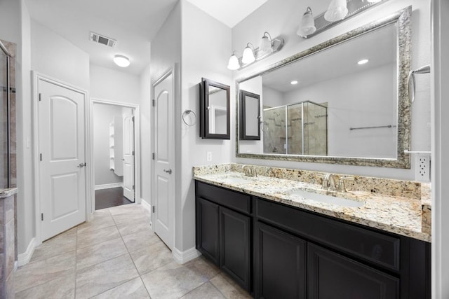 bathroom featuring a shower stall, tile patterned floors, vanity, baseboards, and visible vents
