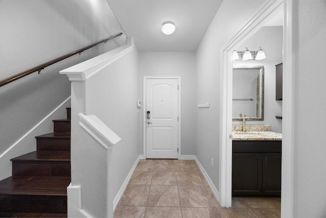 interior space with baseboards, stairs, and light tile patterned floors