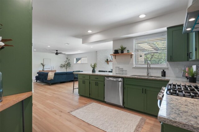 kitchen featuring backsplash, dishwasher, a ceiling fan, light wood-type flooring, and green cabinets