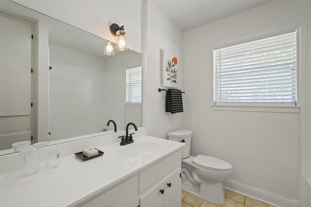 bathroom featuring baseboards, tile patterned floors, vanity, and toilet