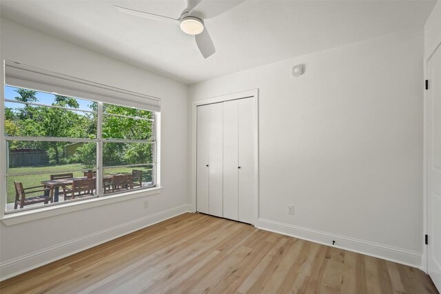 unfurnished bedroom featuring light wood-type flooring, baseboards, a closet, and ceiling fan