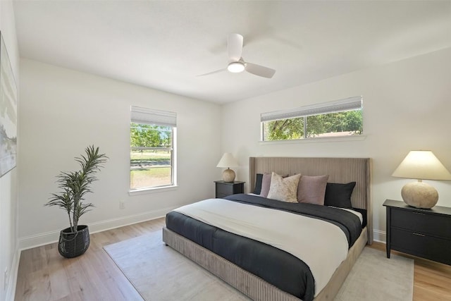 bedroom featuring light wood finished floors, baseboards, and ceiling fan