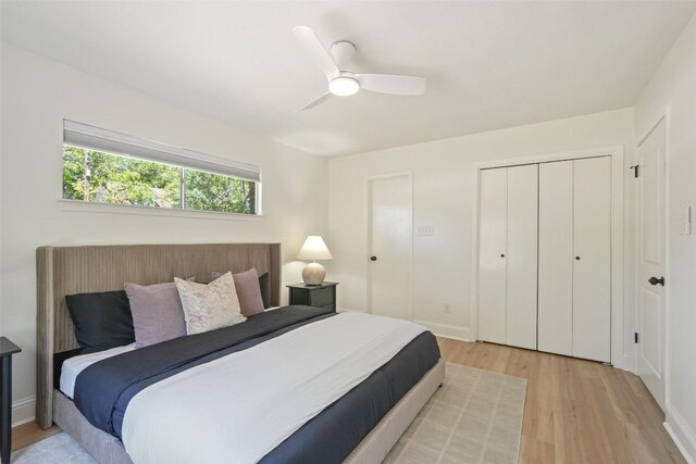 bedroom with a closet, a ceiling fan, and light wood-style flooring