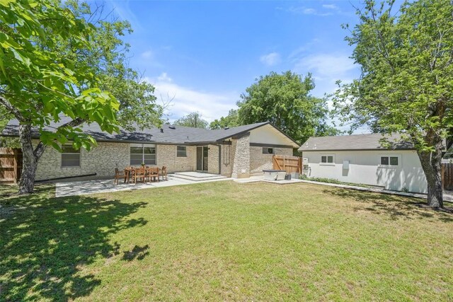 back of property with a patio area, a lawn, and fence
