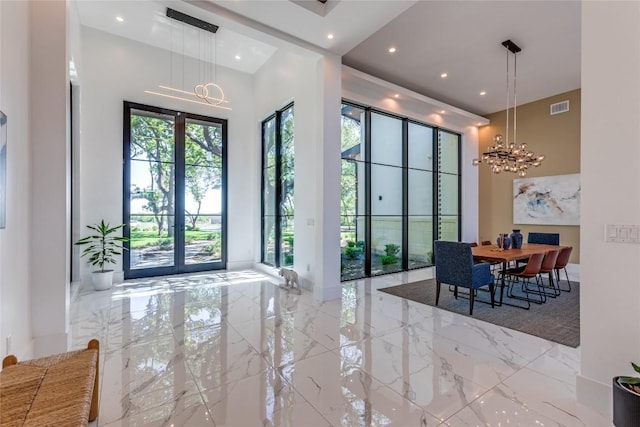 116 Mesones Rd, Florence, TX 76527 - foyer with marble tiled floors, a chandelier, a high ceiling, and recessed lighting