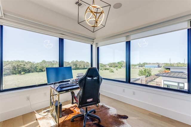 home office with visible vents, baseboards, wood finished floors, and an inviting chandelier