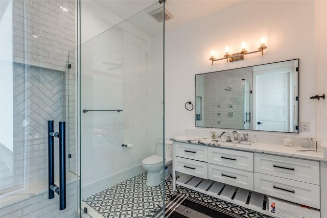 full bathroom featuring vanity, visible vents, a shower stall, and toilet