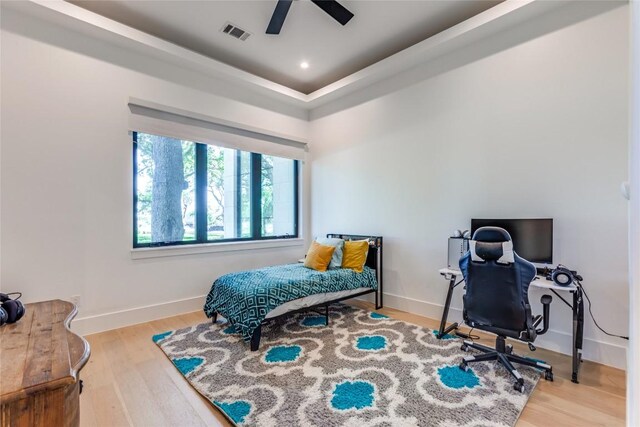 bedroom featuring wood finished floors, visible vents, baseboards, and ceiling fan