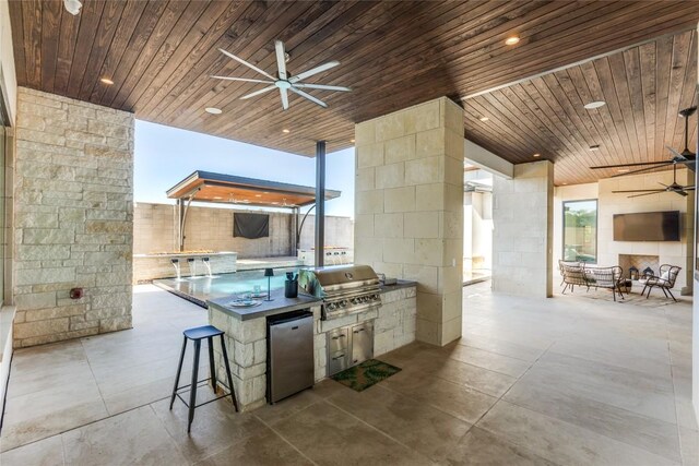 view of patio featuring outdoor wet bar, a ceiling fan, and area for grilling