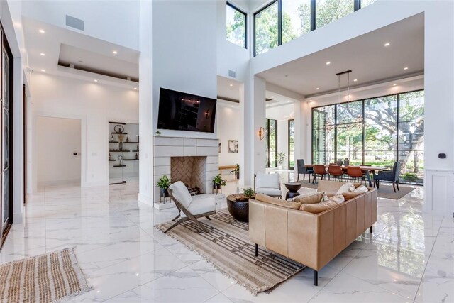 living room featuring plenty of natural light, a high ceiling, and marble finish floor
