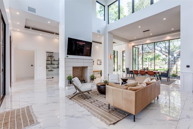 116 Mesones Rd, Florence, TX 76527 - living area featuring a towering ceiling, light marble finish floors, plenty of natural light, and a fireplace with raised hearth