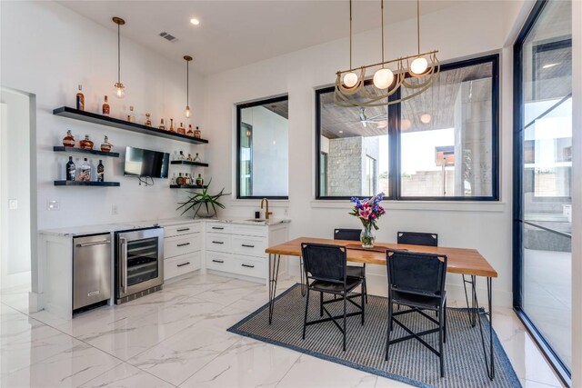 interior space with marble finish floor, indoor wet bar, pendant lighting, wine cooler, and visible vents