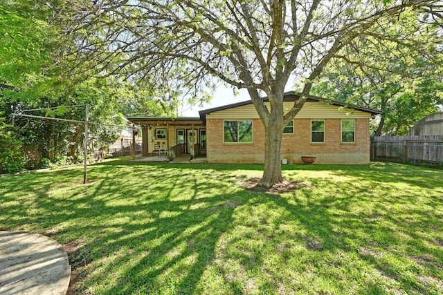 4722 Frontier Trl, Austin, TX 78745 - rear view of house featuring fence, a lawn, and brick siding
