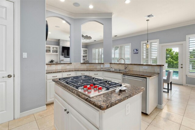 4101 Top Of Texas Trl, Austin, TX 78735 - kitchen featuring stainless steel appliances, backsplash, crown molding, a kitchen island, and dark stone countertops
