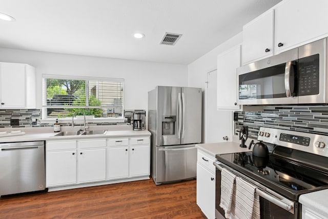 10701 Garbacz Dr, Austin, TX 78748 - kitchen with appliances with stainless steel finishes, a sink, decorative backsplash, light countertops, and dark wood finished floors