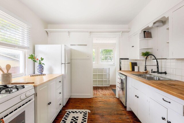1200 Cullen Ave Unit B, Austin, TX 78757 - kitchen with open shelves, backsplash, white appliances, a sink, and dark wood-style flooring