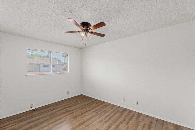 unfurnished room with ceiling fan, baseboards, wood finished floors, and a textured ceiling