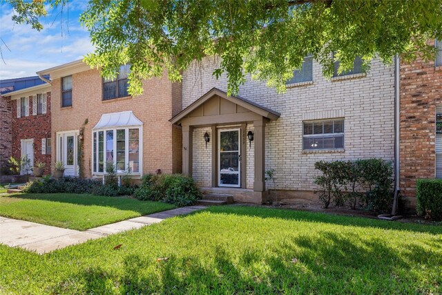 view of front of house with a front lawn and brick siding