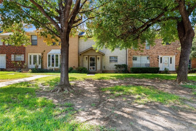 view of front of property featuring brick siding and a front yard