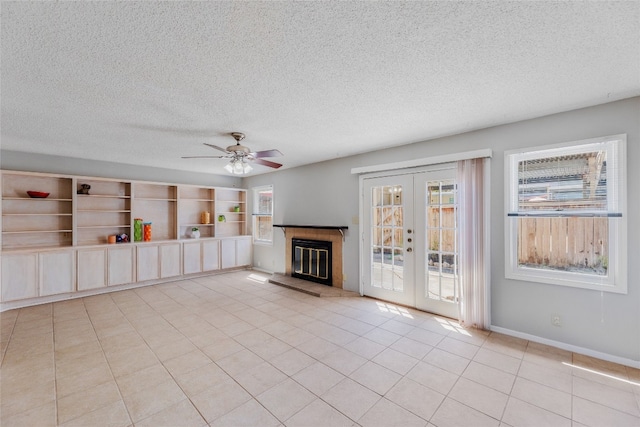 unfurnished living room featuring french doors, baseboards, a textured ceiling, and light tile patterned flooring