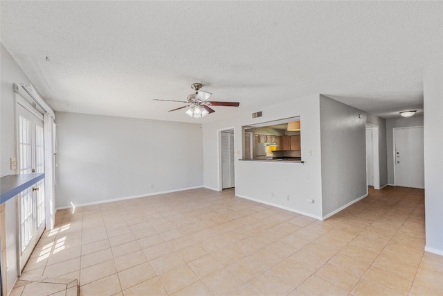 unfurnished living room with visible vents, baseboards, a textured ceiling, and ceiling fan