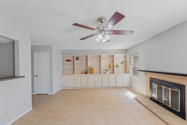 unfurnished living room featuring a fireplace, a textured ceiling, baseboards, and ceiling fan