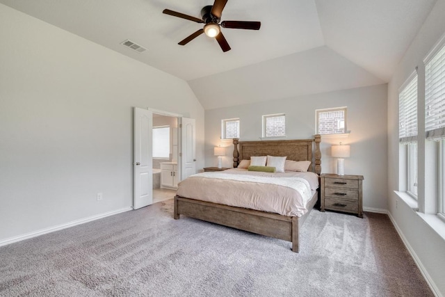 carpeted bedroom featuring connected bathroom, lofted ceiling, visible vents, and baseboards