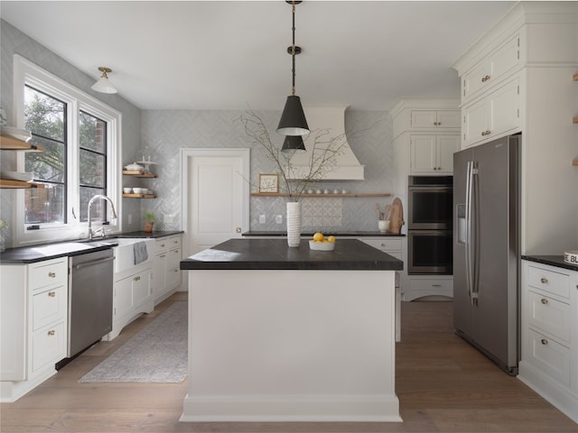 9401 Winchester Rd, Austin, TX 78733 - kitchen with dark countertops, a center island, open shelves, light wood finished floors, and stainless steel appliances
