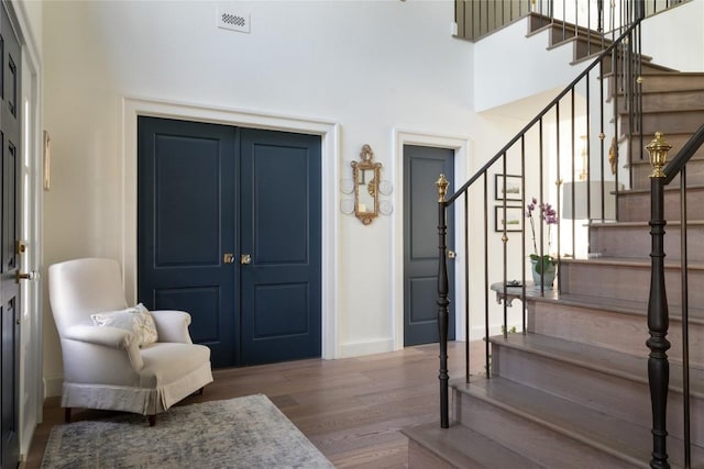 9401 Winchester Rd, Austin, TX 78733 - entrance foyer featuring visible vents, wood finished floors, baseboards, a high ceiling, and stairs
