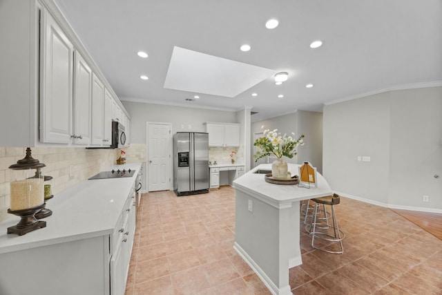 1107 Saint John Ct, Pflugerville, TX 78660 - kitchen with ornamental molding, a skylight, black electric stovetop, and stainless steel fridge with ice dispenser