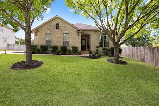 1107 Saint John Ct, Pflugerville, TX 78660 - view of front of property featuring fence, a front lawn, and stone siding