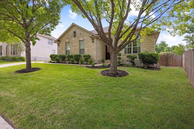 1107 Saint John Ct, Pflugerville, TX 78660 - view of front of property with a front lawn, stone siding, and fence