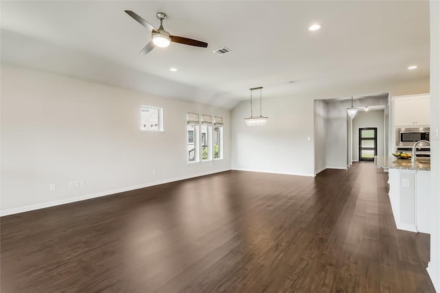 22621 Fountaingrass Ln, Lago Vista, TX 78645 - unfurnished living room with dark wood-style flooring, visible vents, ceiling fan, and baseboards