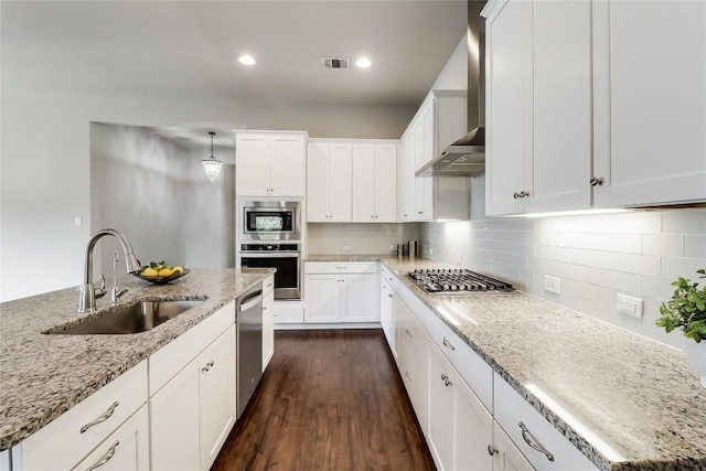 22621 Fountaingrass Ln, Lago Vista, TX 78645 - kitchen featuring light stone countertops, stainless steel appliances, wall chimney range hood, backsplash, and a sink