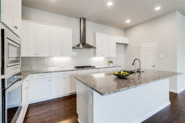 22621 Fountaingrass Ln, Lago Vista, TX 78645 - kitchen with light stone countertops, stainless steel appliances, dark wood-style flooring, a sink, and wall chimney exhaust hood