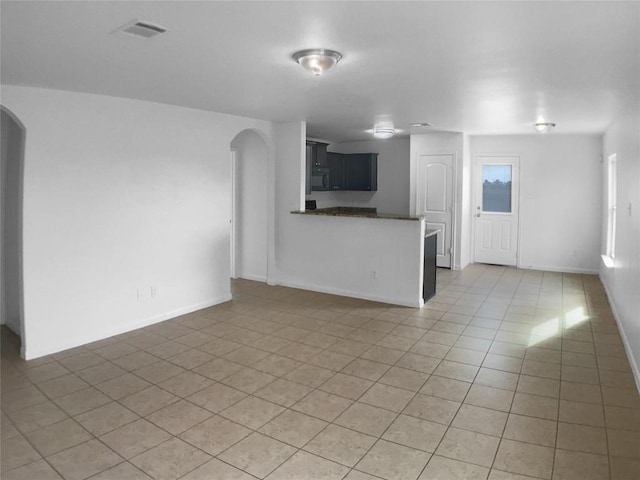 115 Millers Loop, Jarrell, TX 76537 - unfurnished living room with baseboards, visible vents, arched walkways, and light tile patterned flooring