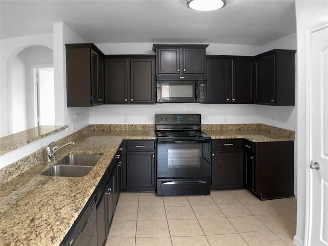 115 Millers Loop, Jarrell, TX 76537 - kitchen with arched walkways, a sink, black appliances, light stone counters, and light tile patterned floors