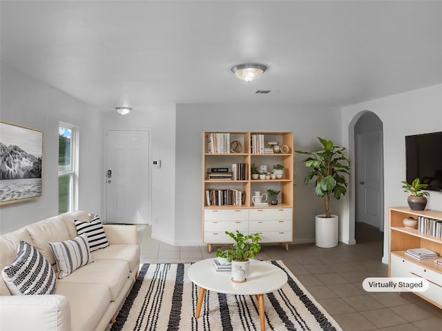 115 Millers Loop, Jarrell, TX 76537 - tiled living room with arched walkways, visible vents, and baseboards