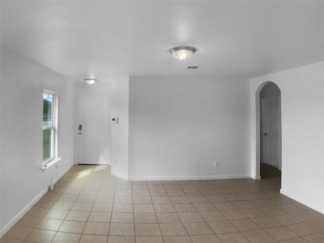 115 Millers Loop, Jarrell, TX 76537 - spare room featuring arched walkways, visible vents, baseboards, and light tile patterned floors