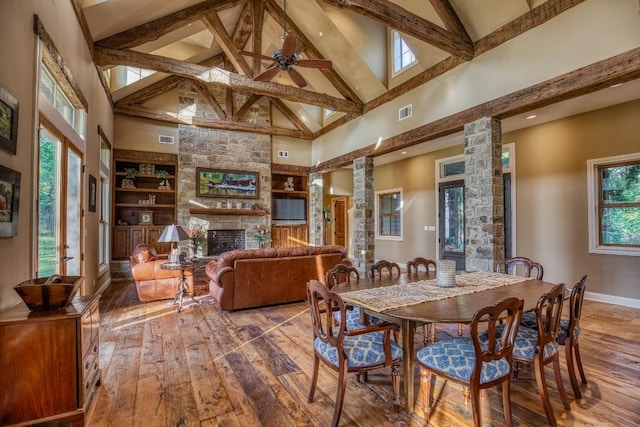 dining area featuring ornate columns, beamed ceiling, baseboards, hardwood / wood-style flooring, and high vaulted ceiling