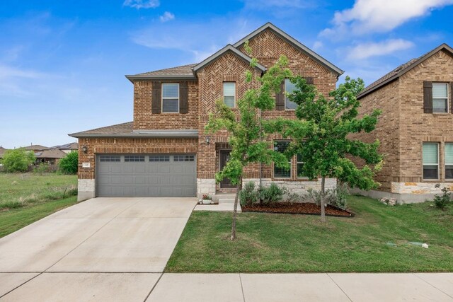 337 Akumal St, Leander, TX 78641 - traditional-style home with brick siding, a front lawn, driveway, a garage, and a shingled roof