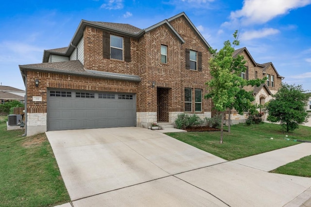 337 Akumal St, Leander, TX 78641 - traditional home with a front yard, brick siding, driveway, a shingled roof, and an attached garage