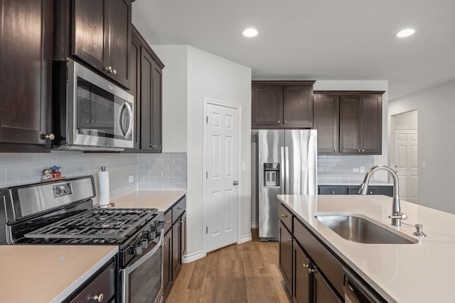 337 Akumal St, Leander, TX 78641 - kitchen featuring stainless steel appliances, a sink, wood finished floors, light countertops, and dark brown cabinets