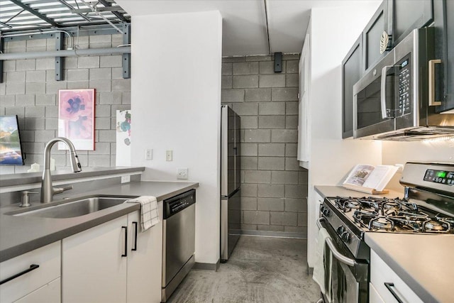 4801 S Congress Ave Unit D6, Austin, TX 78745 - kitchen with appliances with stainless steel finishes, concrete floors, white cabinetry, and concrete block wall