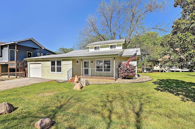 view of front of home featuring metal roof, an attached garage, a front lawn, and aphalt driveway